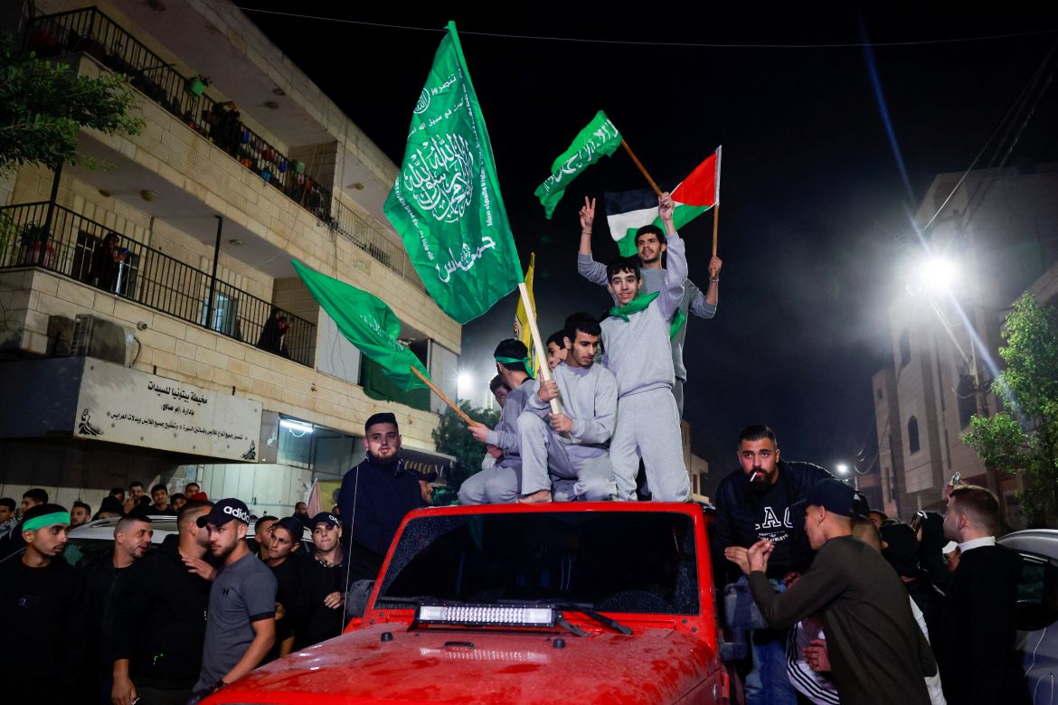 Released Palestinian prisoners wave flags atop a car as they leave the Israeli military prison, Ofer, after hostages-prisoners swap deal between Hamas and Israel near Ramallah in the Israeli-occupied West Bank November 24