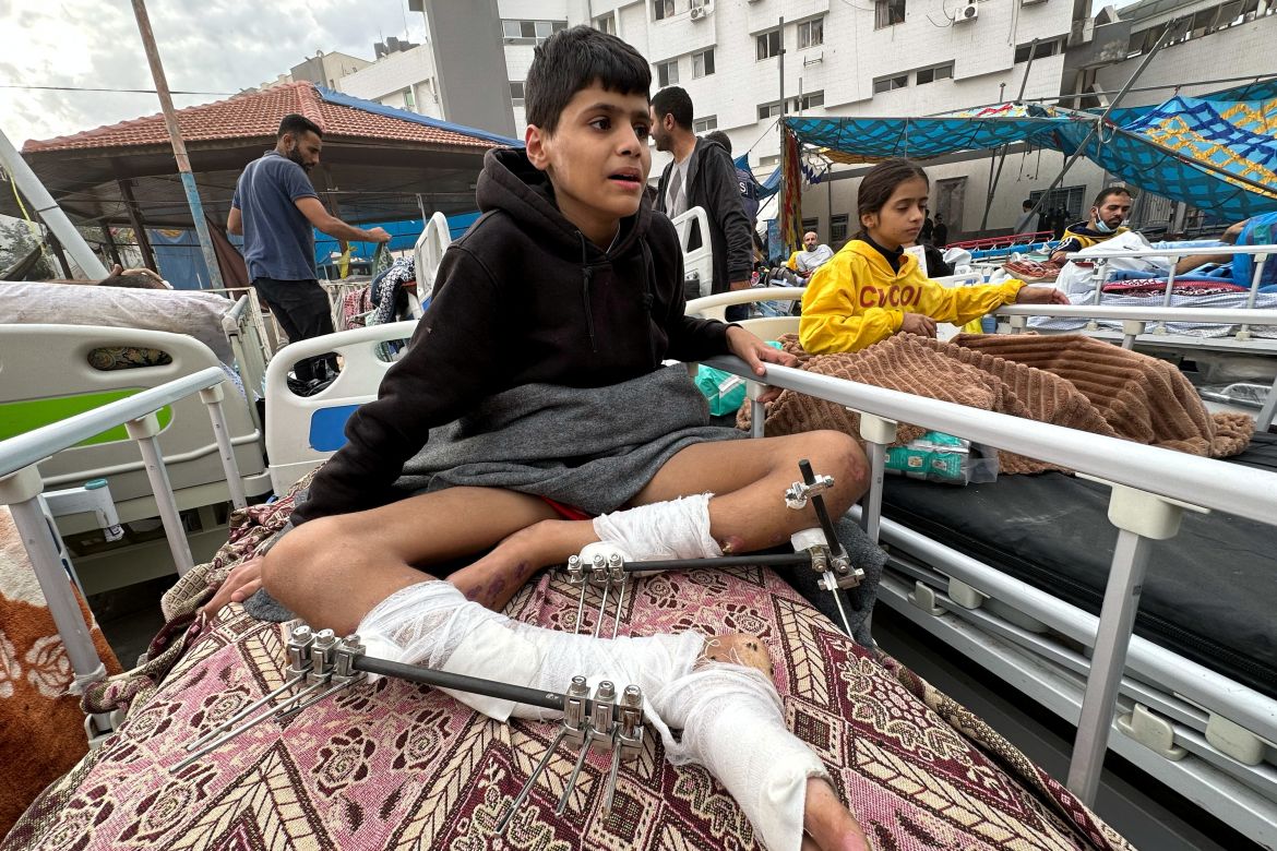 Palestinians wounded in Israeli strikes during the conflict sit on beds at Al Shifa hospital which was raided by Israeli forces during Israel's ground operation, amid a temporary truce between Israel and Hamas in Gaza City