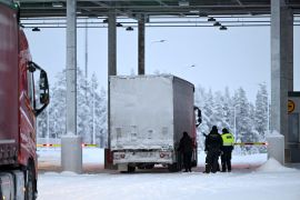 Border guards and a customs official check a truck at the Raja-Jooseppi international border crossing station in Inari, northern Finland on November 28, 2023 [Lehtikuva/Emmi Korhonen via Reuters]