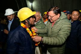 The rescued workers were greeted and garlanded with marigold by Pushkar Singh Dhami, chief minister of Uttarakhand [Handout/Uttarkashi District Information Officer via Reuters]