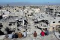 People look at destroyed buildings in Gaza