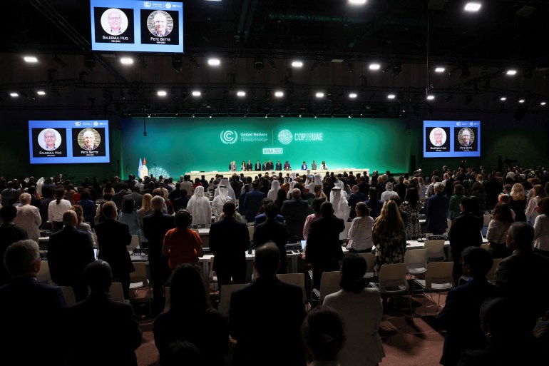 People stand for a moment of silence for victims in Gaza during the United Nations Climate Change Conference (COP28) opening in Dubai, United Arab Emirates, November 30, 2023. REUTERS/Amr Alfiky