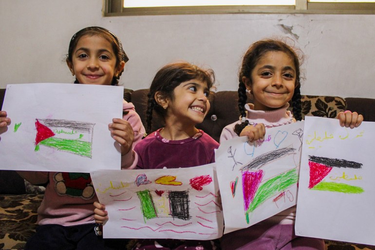 Alaa's girls hold their drawings