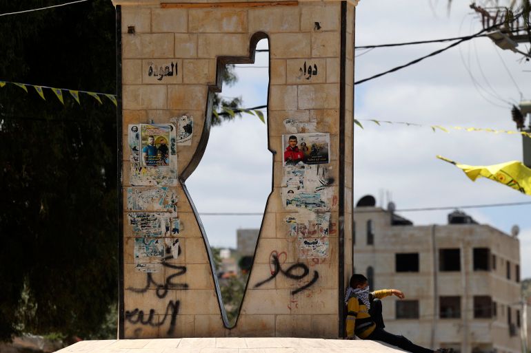 A Palestinian boy walks past a moument showing a map of Mandatory Palestine in the West Bank town of Jenin in the north of the occupied West Bank on April 12, 2022.