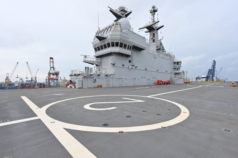 The deck of the French helicopter carrier Dixmude. The deck has a large number 2 in a white circle. The bridge is behind.