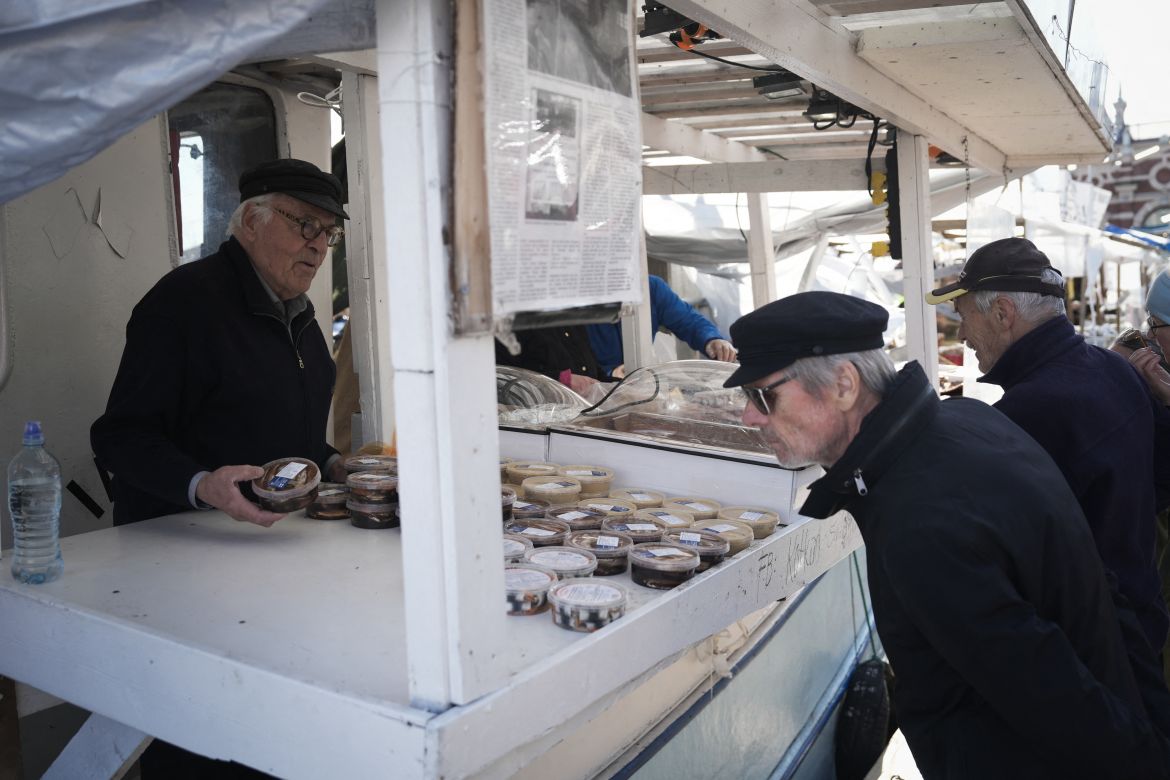 Herring fisherman Holger Sjogren (L) sells herring products on his boat at the fish market in Helsinki, Finland.
