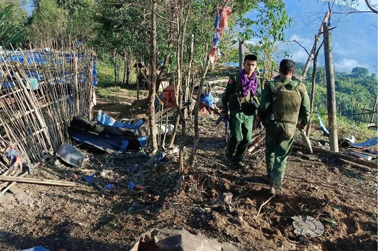 members of the Myanmar National Democratic Alliance Army (MNDAA) in a seized military base. It is in a rural area with bamboo fences.