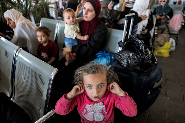 People sit in the waiting area at the Rafah border crossing in the southern Gaza Strip before crossing into Egypt