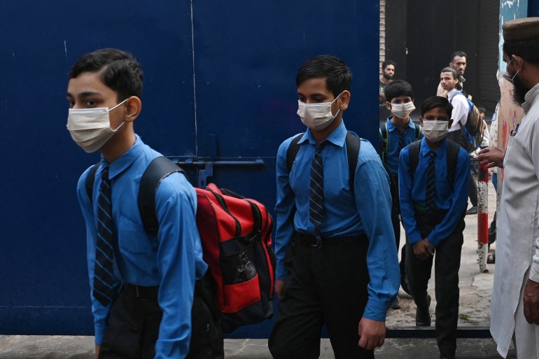 Students wearing facemasks arrive at a school in Lahore on November 2, 2023, following Punjab's government announcement to use facemasks in schools due to severe smoggy conditions. (Photo by Arif ALI / AFP)
