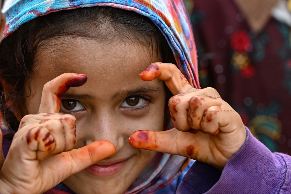 An Afghan refugee girl gestures as she prepares to depart for Afghanistan, at a holding centre, in Landi Kotal.