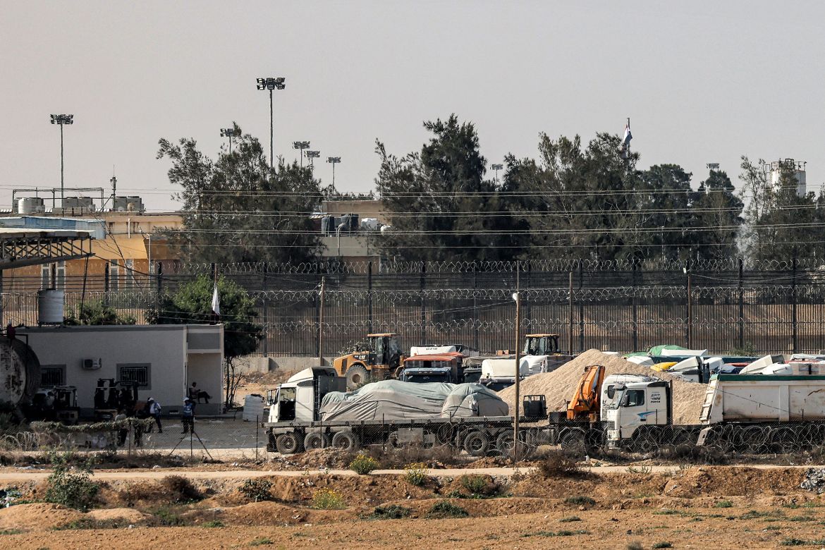 Trucks carrying humanitarian aid wait on the Palestinian side at the Rafah border crossing