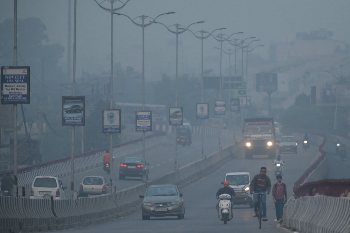 Commuters make their way along a road amid heavy smog conditions in of Amritsar on November 3, 2023. - Schools were shut across India's capital on Friday as a noxious grey smog engulfed the megacity and made life a misery for its 30 million inhabitants.