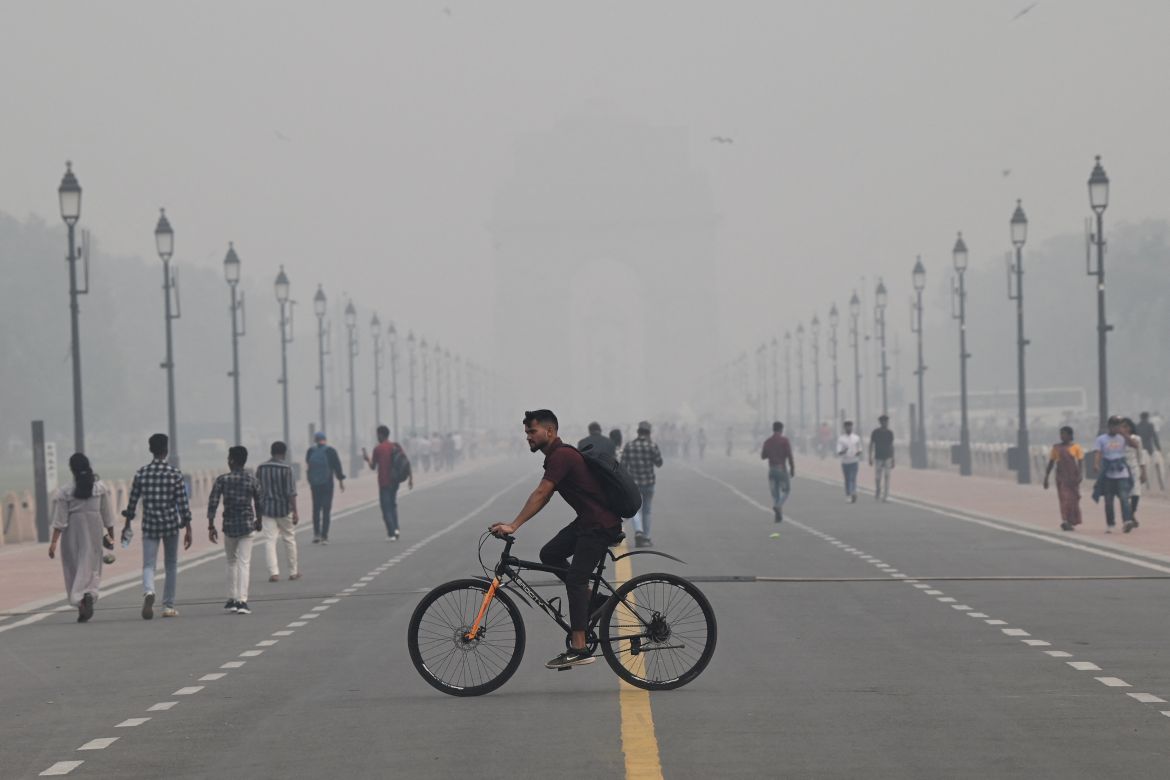 People walk along the Kartavya Path near India Gate amid heavy smog conditions in New Delhi on November 3, 2023. - Schools were shut across India's capital on November 3 as a noxious grey smog engulfed the megacity and made life a misery for its 30 million inhabitants.