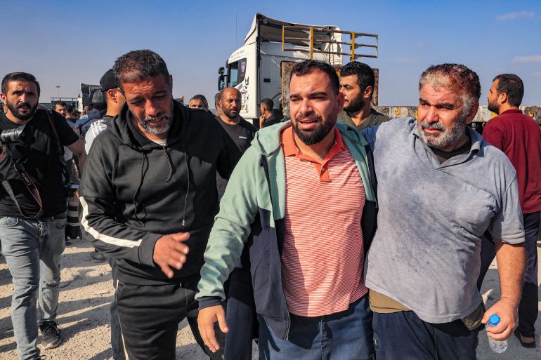 Palestinian workers, who were stranded in Israel since the October 7 attacks, are received as they cross back into the Gaza Strip at the Kerem Shalom commercial border crossing with Israel in the south of the Palestinian enclave on November 3, 2023