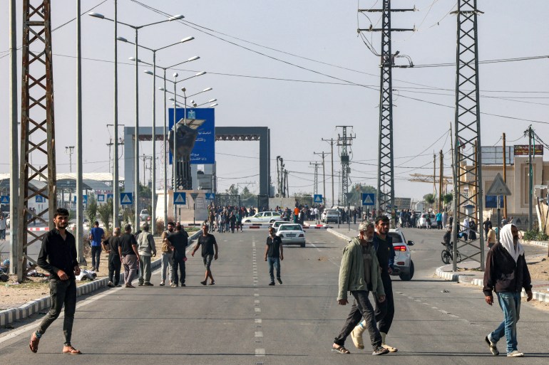 Some of the workers who were stranded in Israel since the October 7 attacks walk near the Rafah border crossing 
