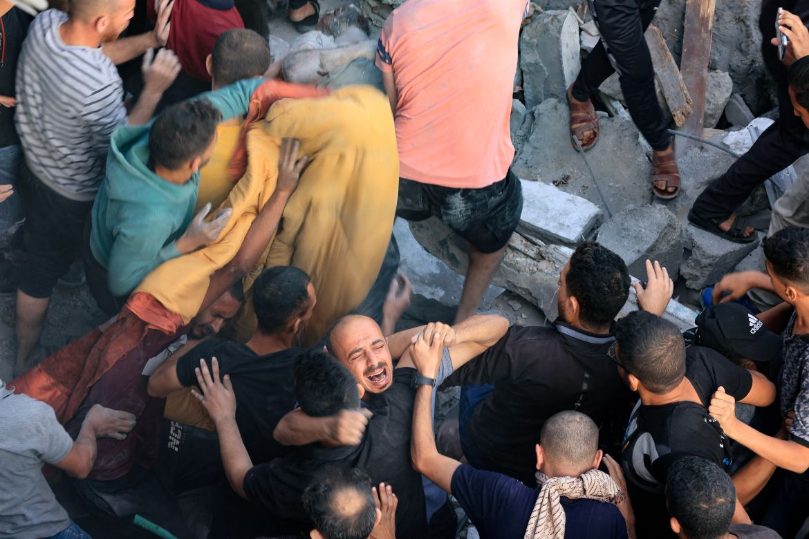 A man reacts as the body of his brother is removed from under the rubble of a building destroyed by an Israeli strike on the Al-Maghazi refugee camp in Deir Balah in the central Gaza Strip.