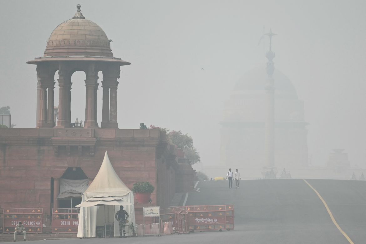 Commuters make their way near India's presidential palace Rashtrapati Bhavan amid heavy smoggy conditions in New Delhi on November 5, 2023. - Authorities in the smog-ridden Indian capital New Delhi on November 5