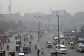 Commuters make their way through a busy street amid smoggy conditions in Lahore on November 7, 2023. (Photo by Arif ALI / AFP)