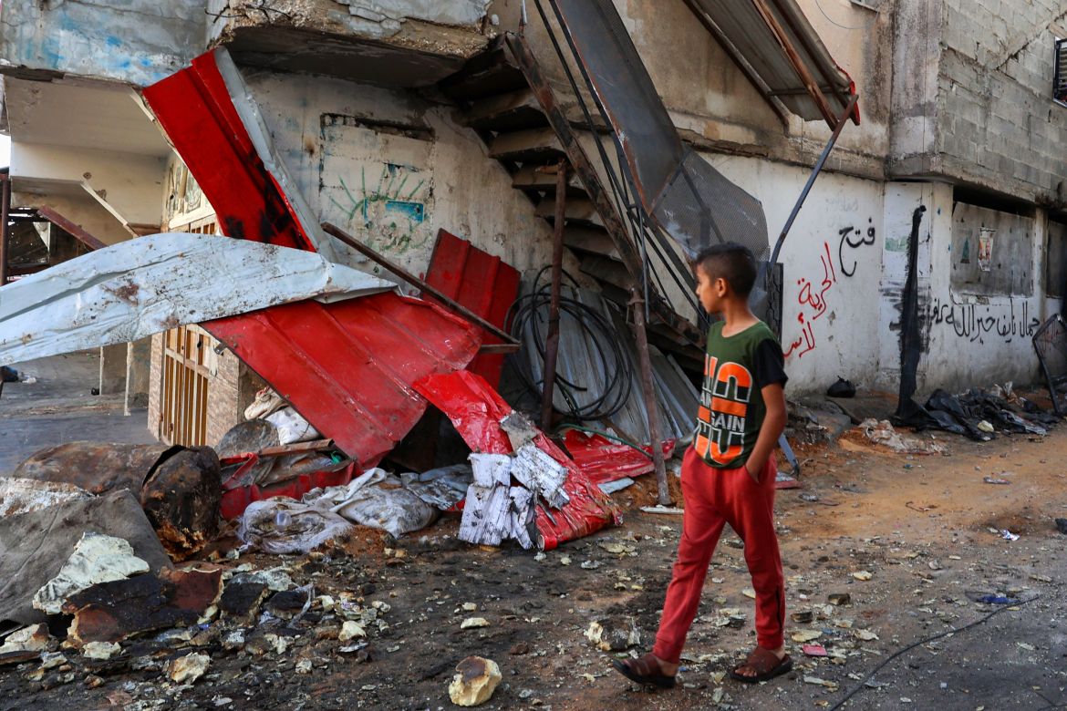 A Palestinian boy walks past a damaged building following an overnight raid by Israeli troops in the Tulkarem refugee camp in the West Bank.