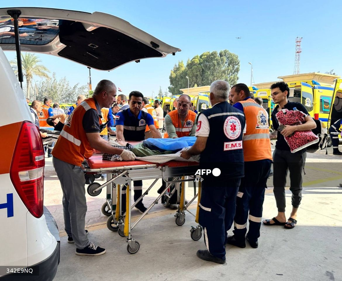 Egyptian paramedics transfer an injured Palestinian woman on the Egyptian side of the Rafah border crossing with the Gaza Strip