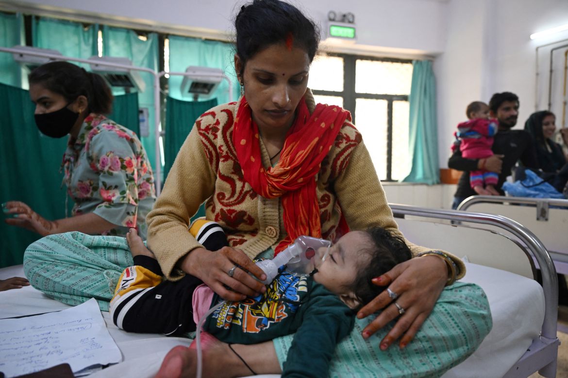 In this picture taken on November 7, 2023, a mother assists her child to breathe with the help of a nebuliser at the emergency ward of the government-run Chacha Nehru Bal Chikitsalaya children hospital in New Delhi.