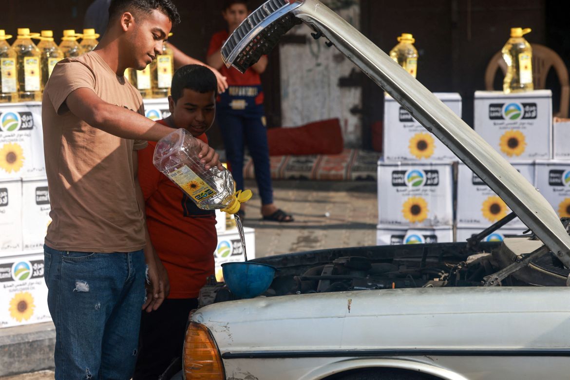 A Palestinian man pours cooking oil into a car in Rafah in the southern Gaza Strip, on November 8, 2023, amid the ongoing battles between Israel and the militant group Hamas.