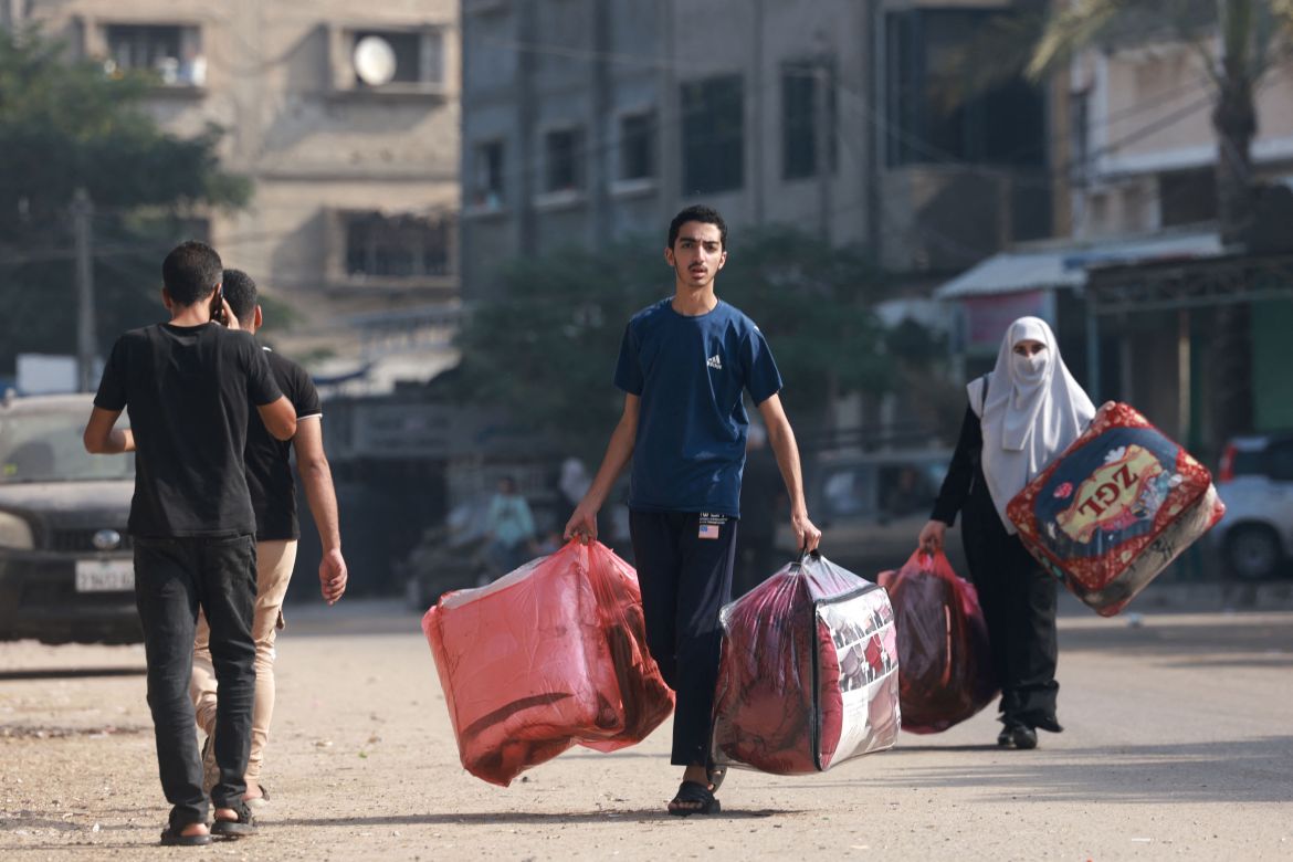 Palestinians carry belongings as they walk in the southern Gaza Strip.