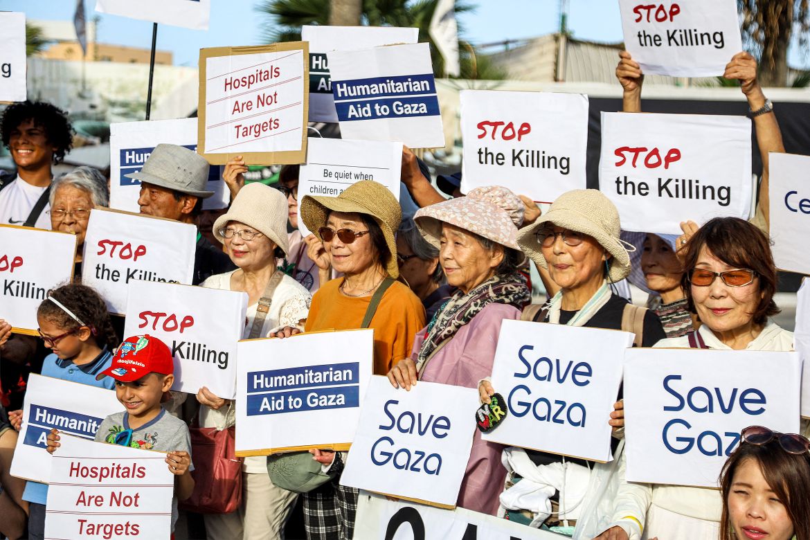 Travellers who were aboard the Panama-flagged cruise ship "Pacific World", sailed by Japan-based luxury cruise operator and NGO "Peace Boat", gather with signs in solidarity with Palestinians in the Gaza Strip as the ship is docked at the port of Port Said at the Mediterranean terminus of the Suez Canal in northeastern Egypt.
