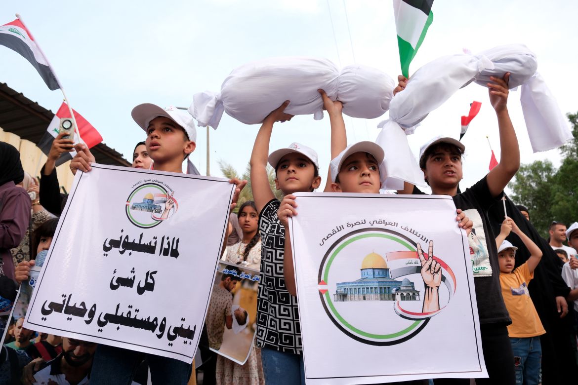 Iraqis carry mock covered bodies as the march during a protest in support of Palestinians in Baghdad .