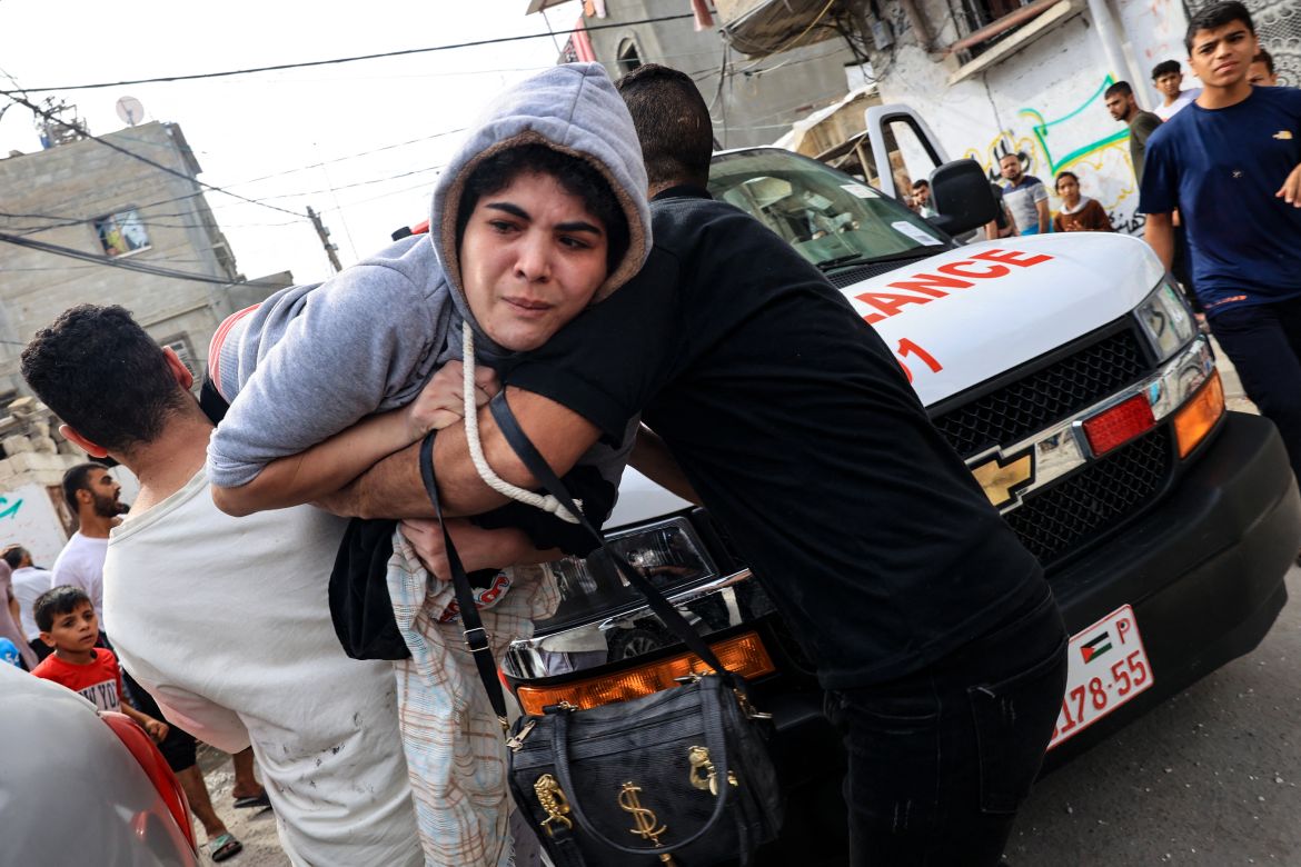 People carry away an injured woman following Israeli bombing on Rafah in the southern Gaza Strip