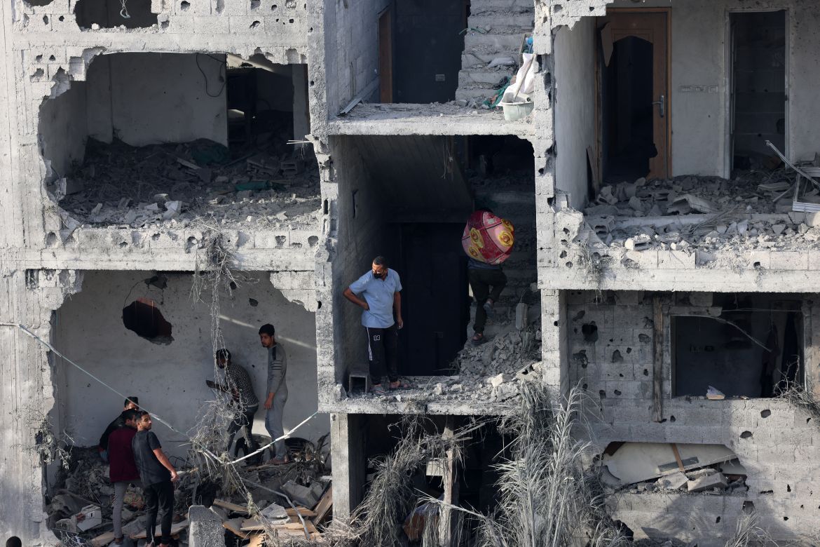 People salvage some belongings from a damaged building following Israeli bombing on Rafah