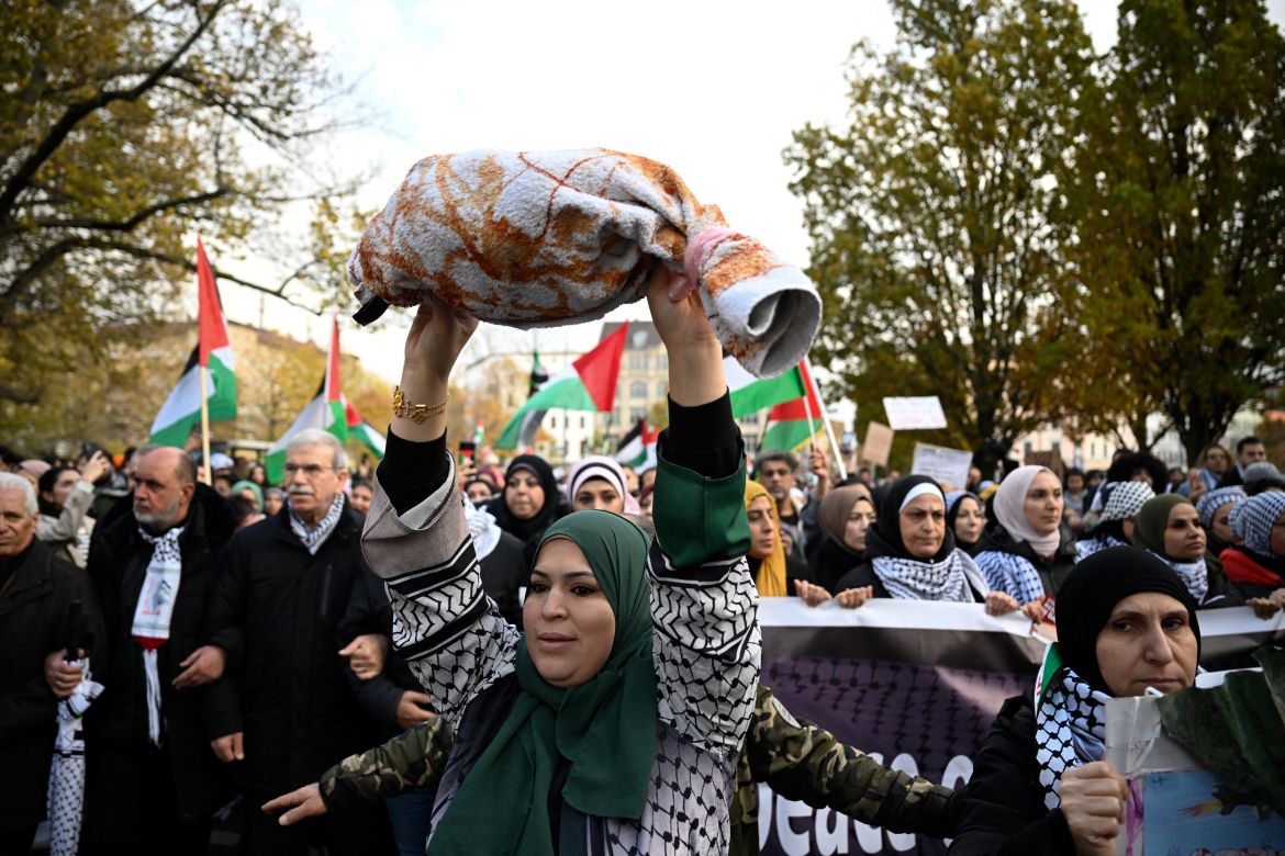 A woman holds a towel to represent a dead child as demonstrators take part in a rally in solidarity with Palestinians at Oranienplatz Square in Berlin's Kreuzberg district, Germany.