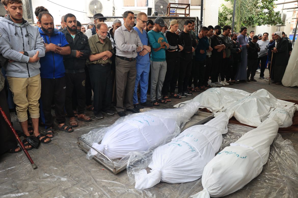 Mourners and medical staff pray over the bodies of Palestinians killed during overnight strikes on Rafah in the southern Gaza Strip, at Al-Najjar hospital.
