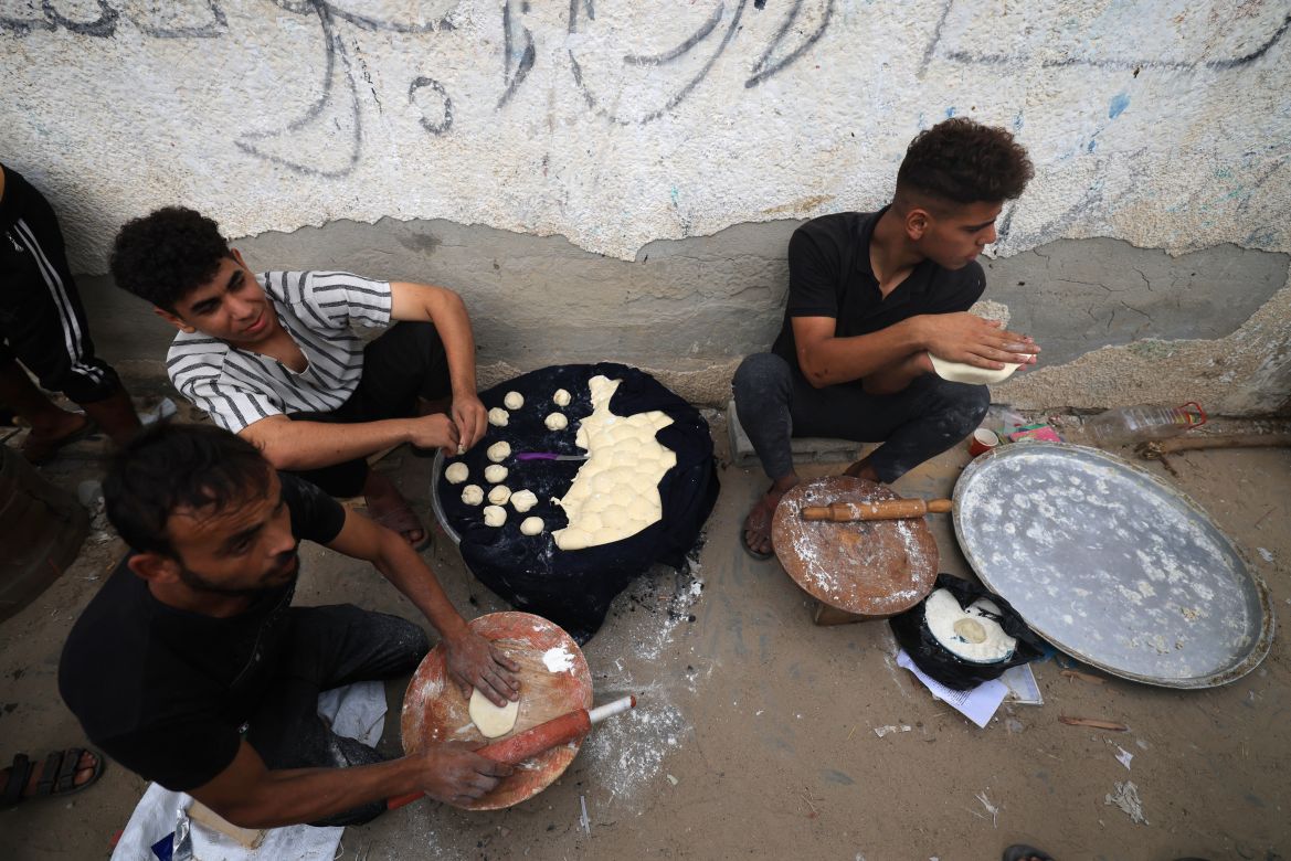Palestinian men prepare dough along a street in Khan Yunis in the southern Gaza Strip.