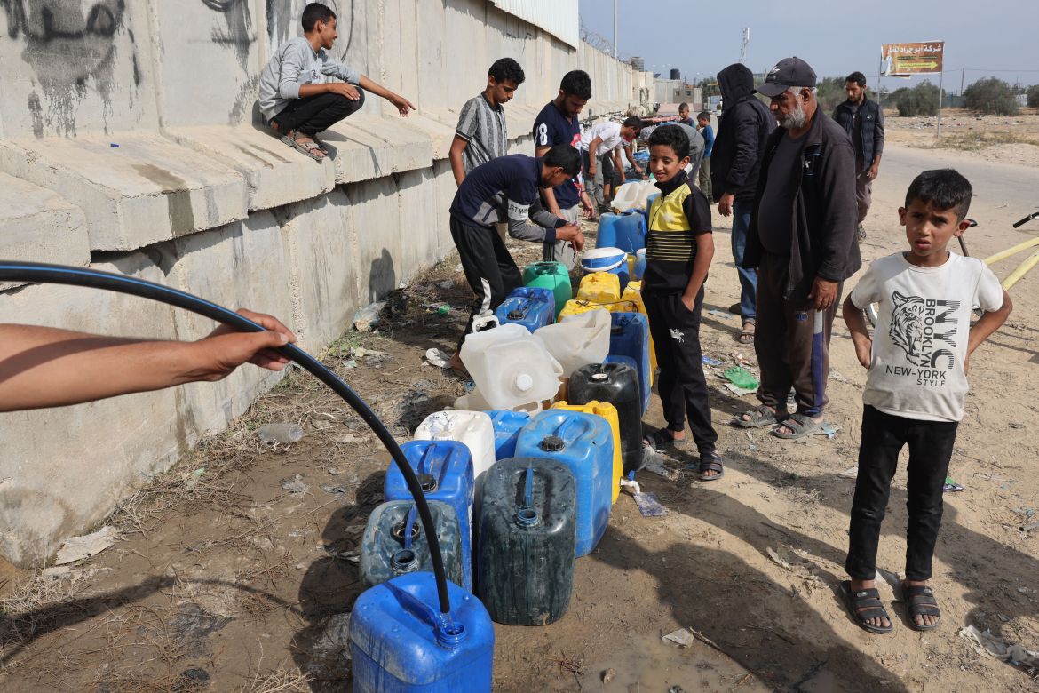 Palestinian children fill containers with water in Rafah, in the southern Gaza Strip on November 13