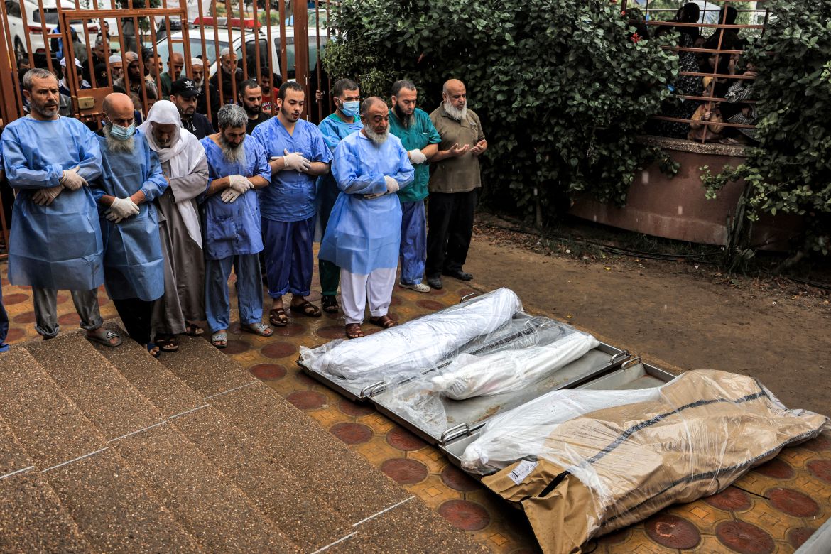 Physicians and other men pray before some of the bodies of victims who were killed in Israeli bombardment before their burial, outside the morgue at Nasser hospital in Khan Yunis in the southern Gaza Strip.
