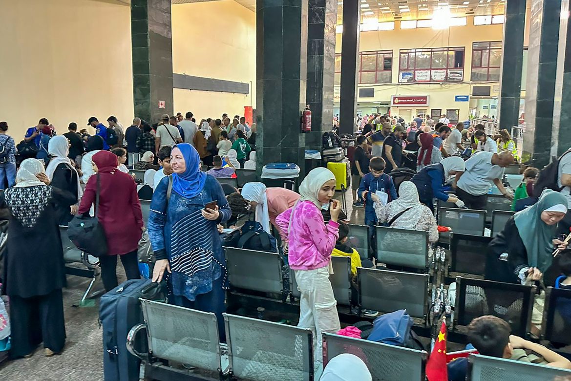 Palestinians and dual nationality holders fleeing from Gaza are pictured on the Egyptian side of the Rafah border crossing with the Gaza Strip.