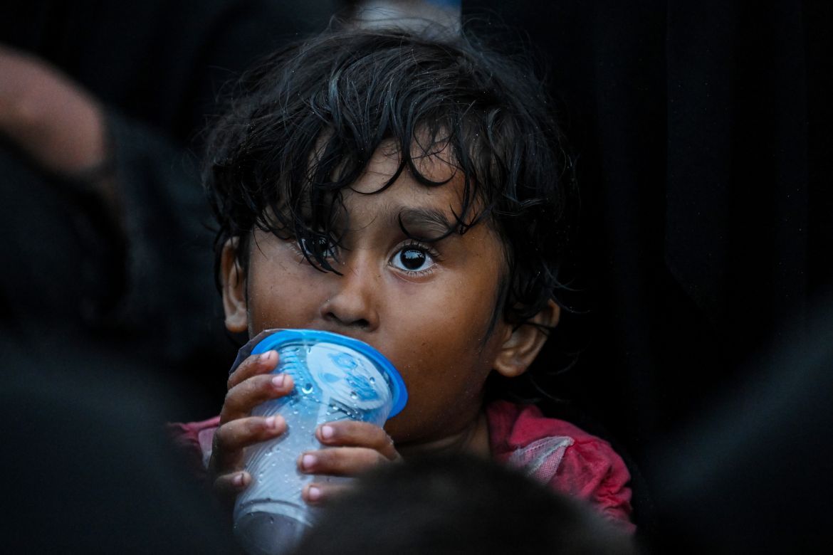 A child of newly-arrived Rohingya refugees drinks water while waiting to be transferred to a shelter in Batee beach, Aceh province, Indonesia.