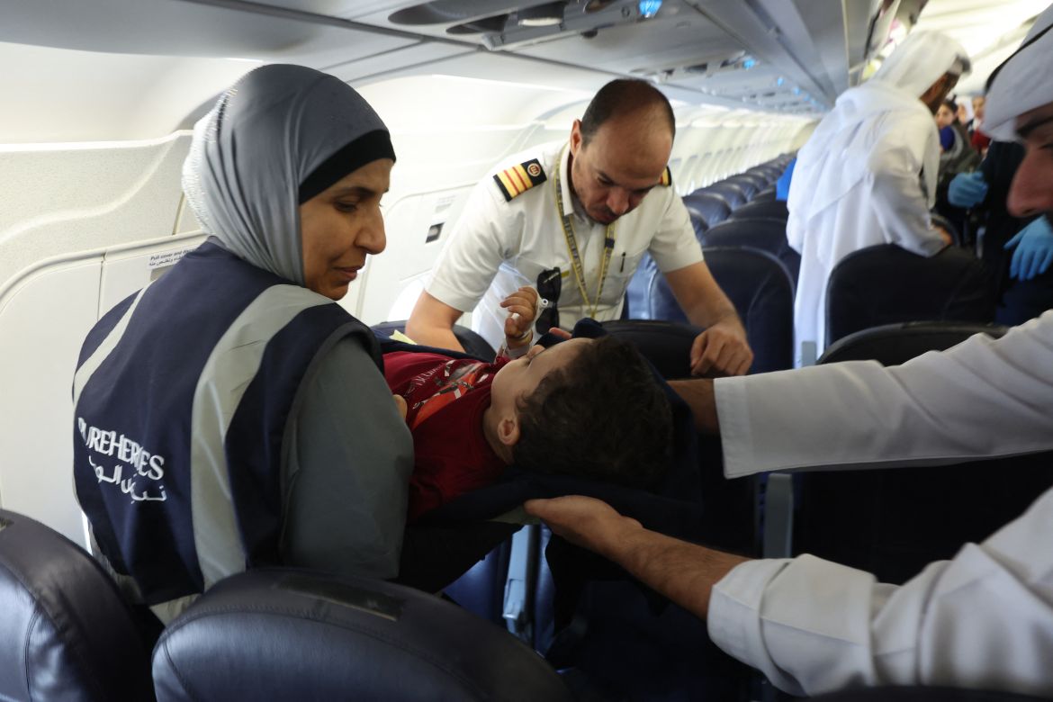 Volunteers transport a wounded Palestinian child off the plane upon their arrival in Abu Dhabi on November 18, 2023, after being evacuated from Gaza as part of a humanitarian mission organised by the United Arab Emirates