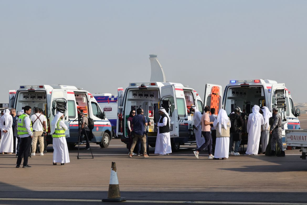 Volunteers and ambulances wait on the tarmac in Abu Dhabi on November 18, 2023, upon the arrival of the plane carrying evacuated Palestinians from Gaza as part of a humanitarian mission organised by the United Arab Emirates