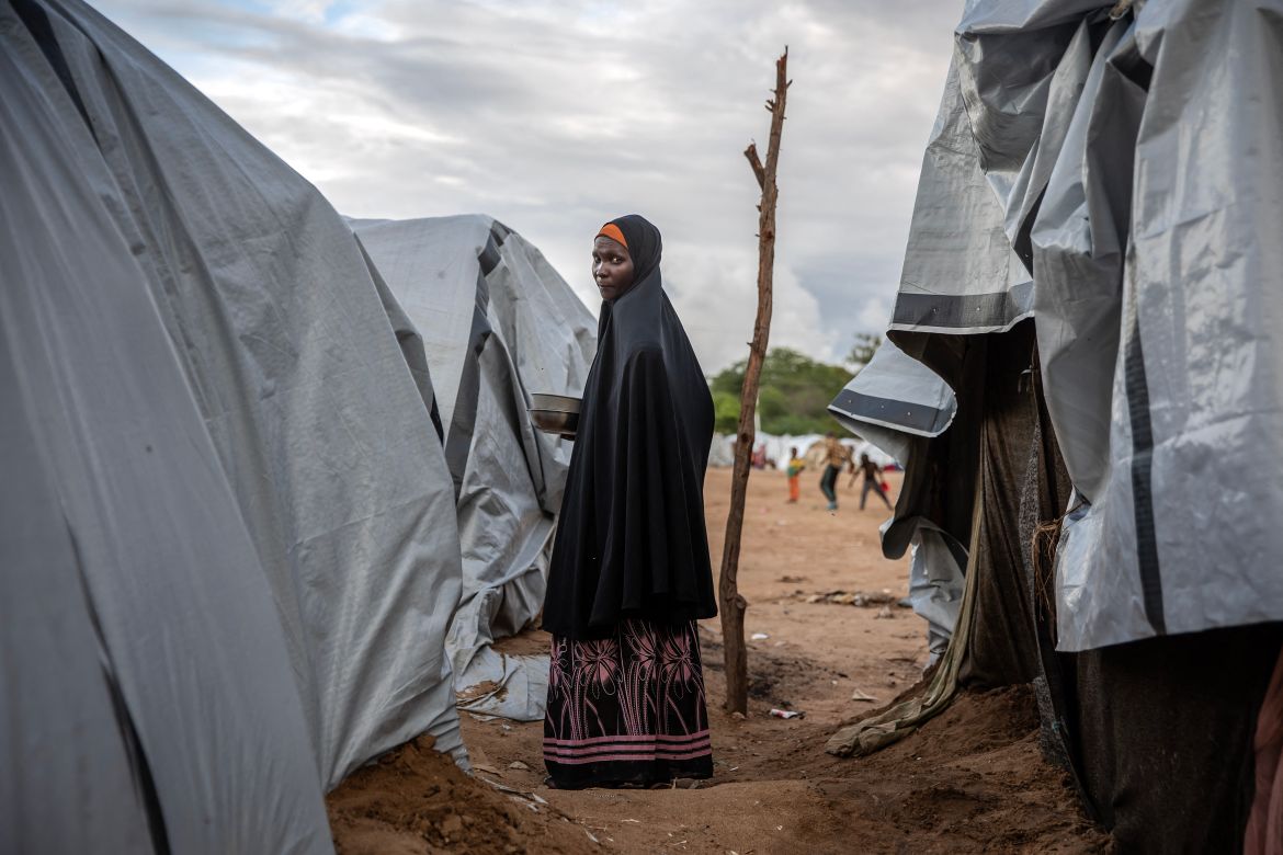 A woman stands in front of the shelter where she lives with her family at an internally displaced persons (IDP) camp for families displaced by floods in Garissa.