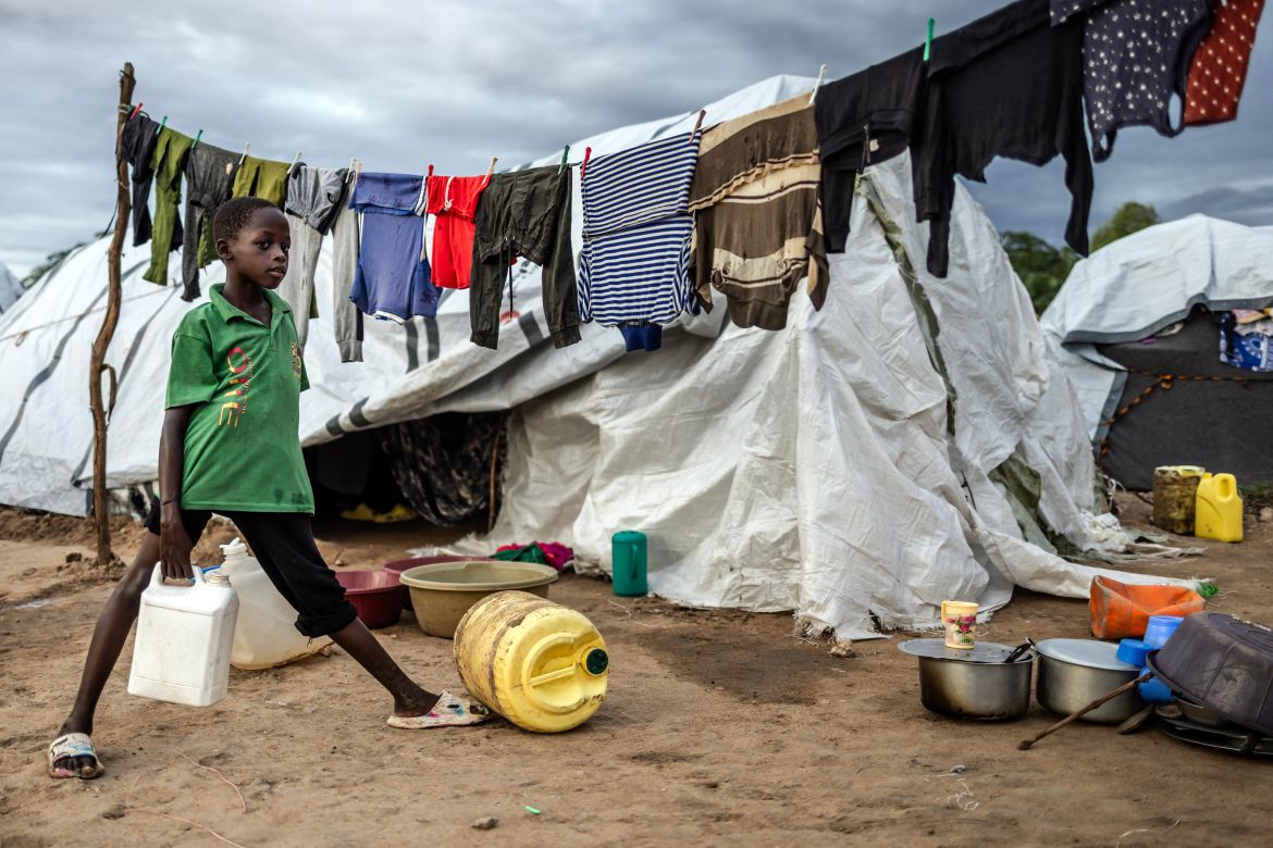 A boy carries water next to the tent where he lives with his family at an internally displaced persons (IDP) camp for families displaced by floods in Garissa.