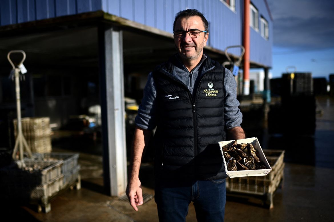 This picture shows manager of the Chiron oyster-farming company Laurent Chiron holding a basket of Marennes Oleron oysters in L'Eguille along the Seudre river, south-western France.