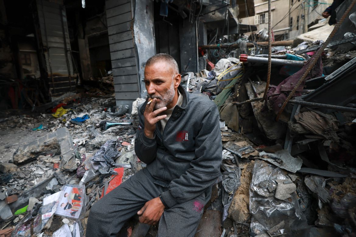 A Palestinian man smokes a cigarette amid the rubble in the southern Gaza Strip city of Khan Yunis.
