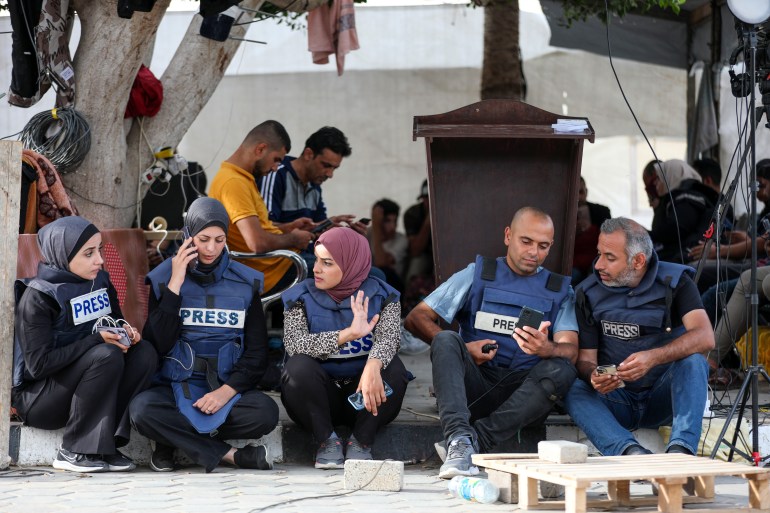 Palestinian journalists sitting in the courtyard of Al-Aqsa Martyrs Hospital in Deir al-Balah 