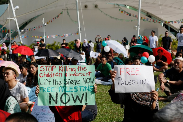 A 2014 protest at Speakers' Corner, the only place where Singaporeans are allowed to hold protests. People are holding placards reading 'Free Palestine', 'Stop killing the children'. Some have red, white and green balloons.