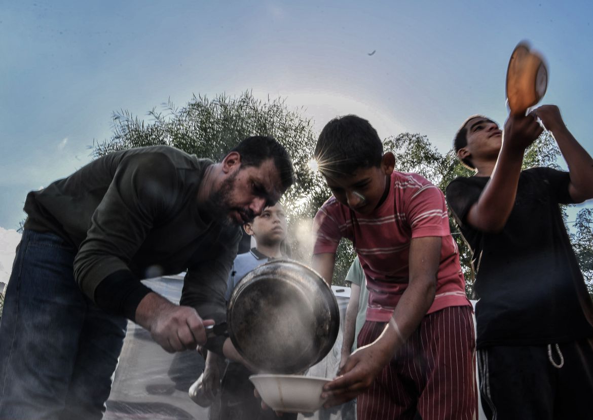 Volunteers distribute meals to Palestinian families who displaced to the area around Nasser Hospital as Palestinians try to continue their daily lives amid Israeli attacks in Khan Yunis, Gaza.