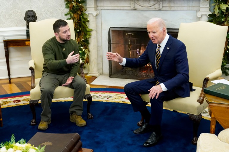 Il presidente Joe Biden e il presidente Volodomyr Zelenskyy siedono insieme nello Studio Ovale, su grandi sedie beige con lo schienale alto.