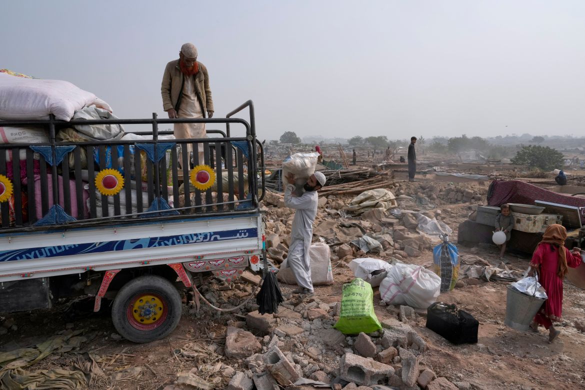 Afghans load their belongings in a vehicle after retrieving them from their damaged mud homes demolished by authorities during a crackdown against an illegal settlement and immigrants, on the outskirts of Islamabad, Pakistan.