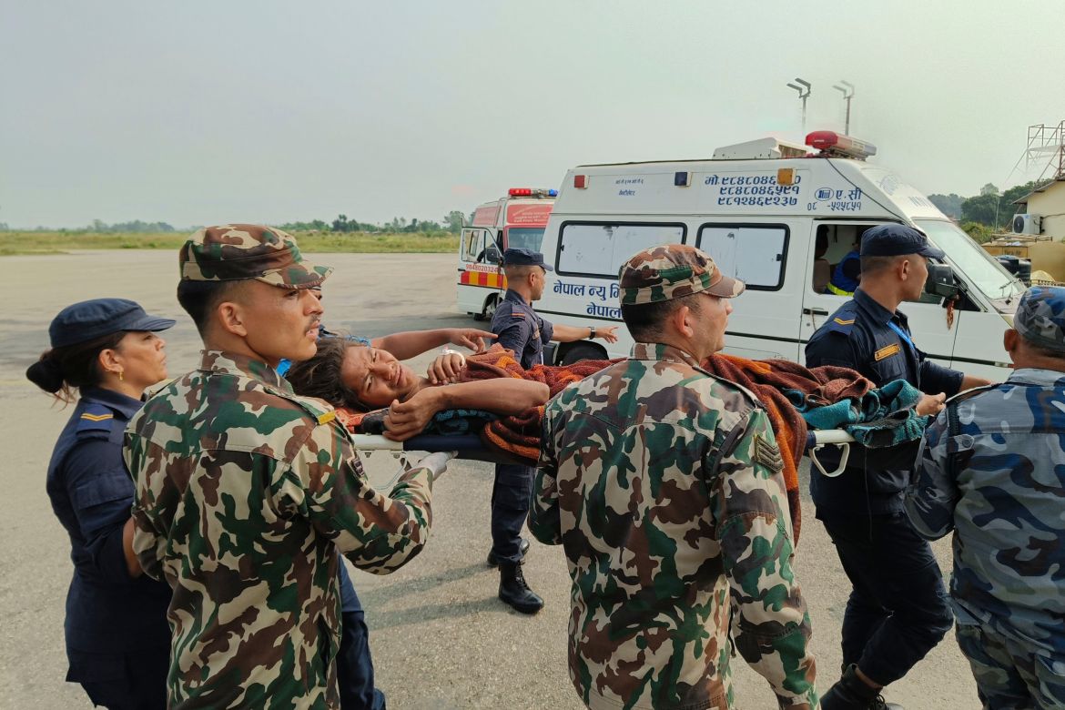 A woman airlifted from an earthquake-affected area is carried on a stretcher in Nepalgunj, Nepal, Saturday